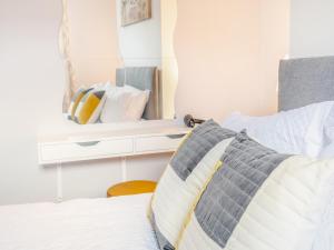 a bedroom with a bed with a mirror on the wall at Buttercup Apartment - Uk42382 in Bridlington +5 photos