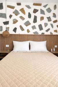 a bedroom with a large bed with a wall at Harmonia Himara in Himare