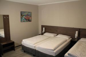 a bedroom with two beds and a picture on the wall at Fair Hotel Europaallee in Frankfurt +10 photos