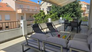 a balcony with a couch and a table and chairs at CENTRO POOL House in Novalja