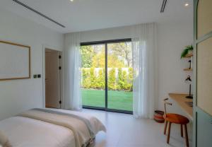 a bedroom with a bed and a large window at Villa Mansour in Abu Dhabi +14 photos