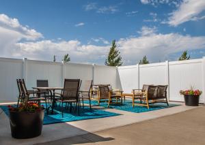 a patio with a table and chairs and a fence at Canalta Hotel Oyen in Oyen