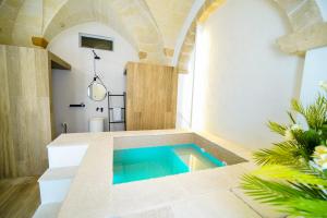 a bathroom with a swimming pool in the middle of a room at Liconti Exclusive Rooms in Pulsano