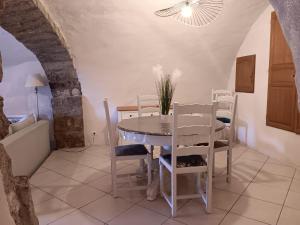 a dining room with a table and chairs at Maison ardéchoise atypique in Chomérac