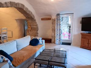 a living room with a couch and a tv at Maison ardéchoise atypique in Chomérac