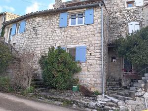 an old stone house with blue windows and stairs at Maison ardéchoise atypique in Chomérac