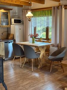 a kitchen with a wooden table with chairs and a table at Domek Jaśka in Baligród +21 photos