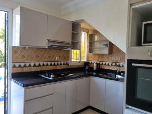 a kitchen with white cabinets and black counter tops at Appartement Imi-Ouaddar 1 in Agadir nʼ Aït Sa