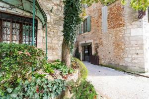 a brick building with a tree in front of it at Hôtel Jean XXII in Cahors