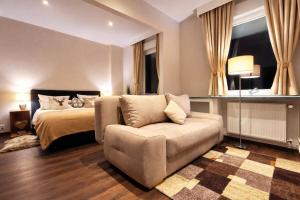 a bedroom with a bed and a couch at Hotel Wappenhof in Braunlage
