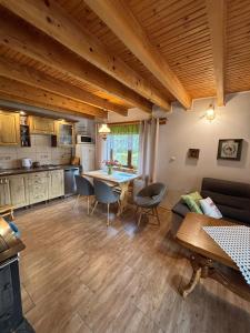 a kitchen and living room with a table and chairs at Domek Jaśka in Baligród