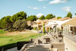 a patio with chairs and umbrellas in a house at Appartement Terrasse avec Vue exceptionnelle Golf in Saumane-de-Vaucluse