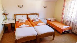 a bedroom with three beds and a table and a phone at Pension Paunasul in Buşteni