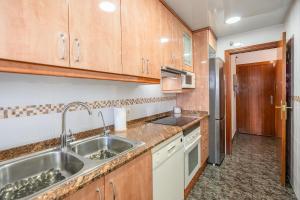 a kitchen with a sink and a refrigerator at Euma Apartment in Cunit +24 photos