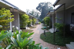 a brick walkway between two buildings with plants at B Town Resort Near Infopark Kakkanad in Kakkanad