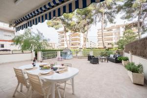 a patio with a white table and chairs at Euma Apartment in Cunit