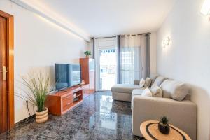 a living room with a couch and a tv at Euma Apartment in Cunit