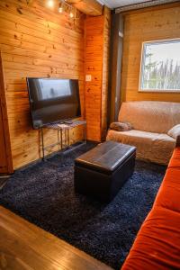 a living room with a couch and a flat screen tv at Maison Conteneur d'Expedition in Amos
