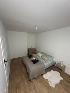 a bedroom with a bed and a wooden floor at 2 chambres pour 6 pers proche plage et cap gris nez in Calais