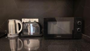 a microwave and a toaster oven next to a toaster at Abbi Holiday Entire Private Villa with Swimming Pool - jaffna town in Jaffna