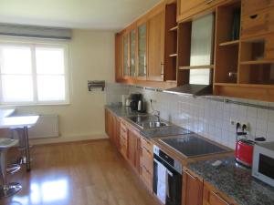 a kitchen with wooden cabinets and a counter top at Ferienwohnung Alpenvilla in Bischofswiesen