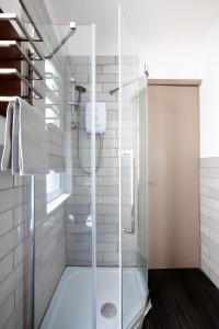 a shower with a glass door in a bathroom at CITY HEART BRIGHTON in Brighton & Hove