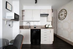 a kitchen with white cabinets and a black dishwasher at CITY HEART BRIGHTON in Brighton & Hove