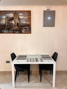 a white table with chairs and a painting on the wall at Park Street Apartment in Trofwi