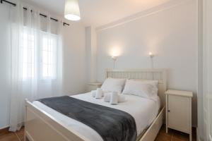 a white bedroom with a bed with white pillows at Marina IV by Ĥ - Marina Isla Canela PMHIV25P25 in Isla del Moral +20 photos