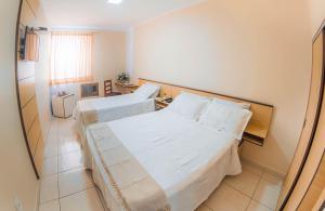a hotel room with two beds and a window at Antico Plaza Hotel in Taubaté +18 photos