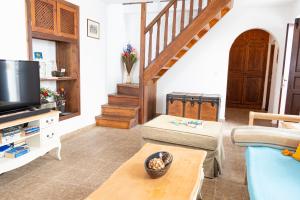 a living room with a couch and a tv at Elegant-Lindian Villa Marietta in Lindos
