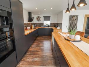 a large kitchen with a wooden counter top at The Joiners Cottage in Morpeth