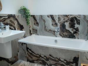 a bathroom with a sink and a bath tub at The Joiners Cottage in Morpeth +42 photos