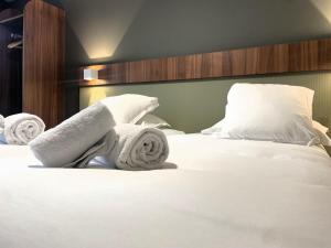 a bedroom with a bed with towels on it at Best Western Hotel Le Crystal Dinard in Dinard +75 photos