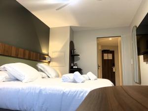 a bedroom with two beds with white pillows at Best Western Hotel Le Crystal Dinard in Dinard