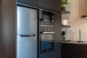 a stainless steel refrigerator in a kitchen at Essence Villas - Garden & Spa in Ribeira Grande