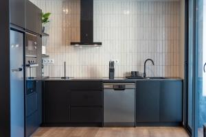 a kitchen with black cabinets and a dishwasher at Essence Villas - Garden & Spa in Ribeira Grande +6 photos