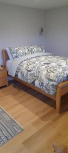 a bed in a room with a wooden frame and a wooden floor at The Loch Cabin in Fort William