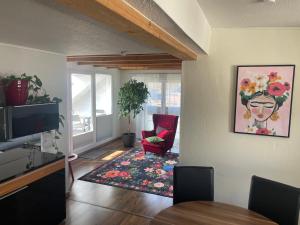 a living room with a red chair and a rug at Fewo extraschön - Dachgeschoss in Lindau