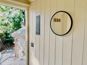 a mirror on the side of a house at Cwt Tyddyn Shepherd's Hut in Corwen