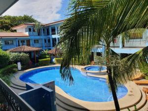 a swimming pool with a palm tree next to a building at Marina Loft unit 2 floor, 201 in Coco