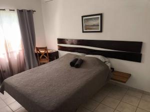 a bedroom with a bed with two brown slippers on it at Marina Loft unit 2 floor, 201 in Coco