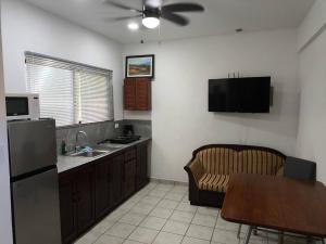 a kitchen with a refrigerator and a table and a chair at Marina Loft unit 2 floor, 201 in Coco