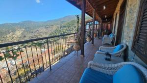 a balcony with chairs and a view of the mountains at CasaLambra Pedoulas Exclusive Accomodation Troodos Mountains in Pedoulas +69 photos