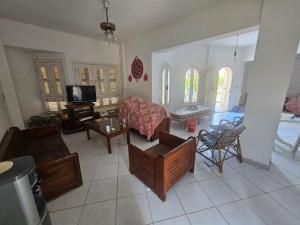 a living room with a couch and a tv at Modern Luxury Villa Steps from the Sea North Coast in Borg El Arab