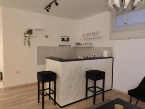 a kitchen with a counter and two stools at Apartman Centar Surcin 2 in Surčin