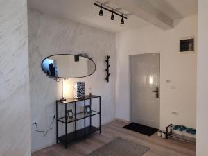 a room with a mirror and a table with a lamp at Apartman Centar Surcin 2 in Surčin