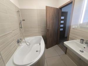 a bathroom with a white tub and a sink at Horský apartmán U Čerťáka in Horní Václavov +6 photos
