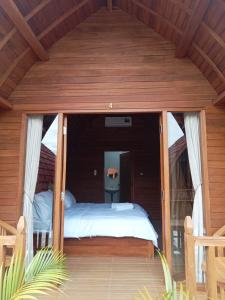 a bedroom with a bed in a wooden room at Lokasea Villa Bali in Pengastulan