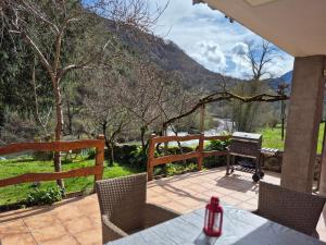a patio with a table and chairs and a grill at Loft Miradas al Sella in Corigos